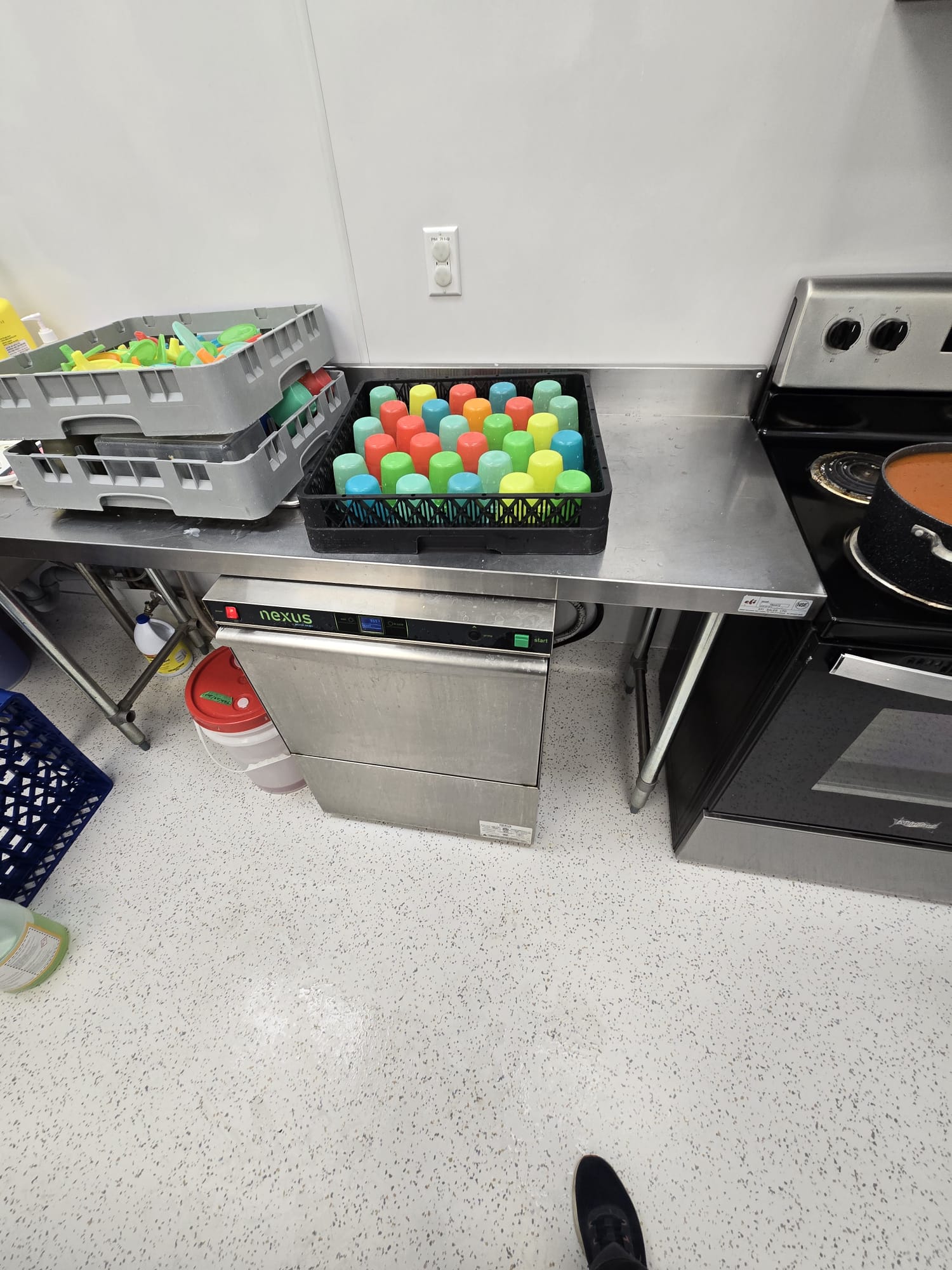 Commercial under-counter dishwasher servicing dishware for a local business